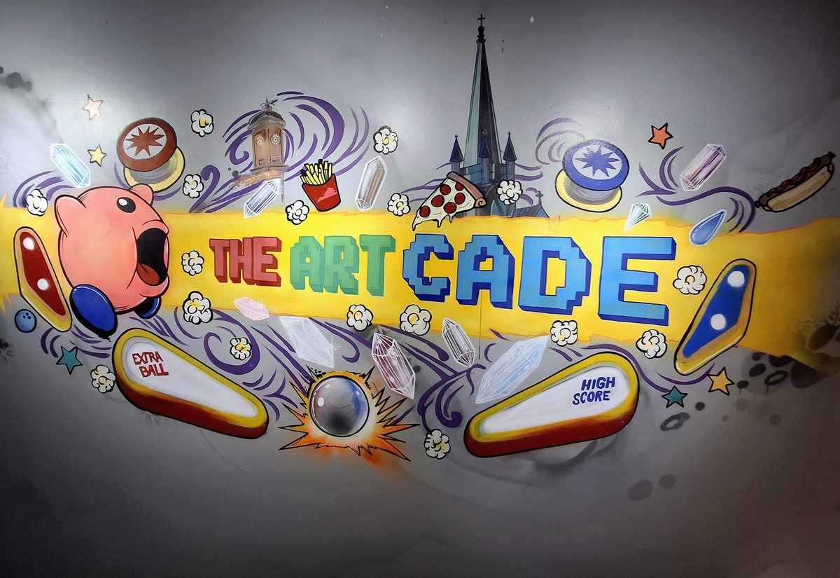 The painted Art-Cade mural: a pink video-game character, pinball flippers and the Staunton clock tower